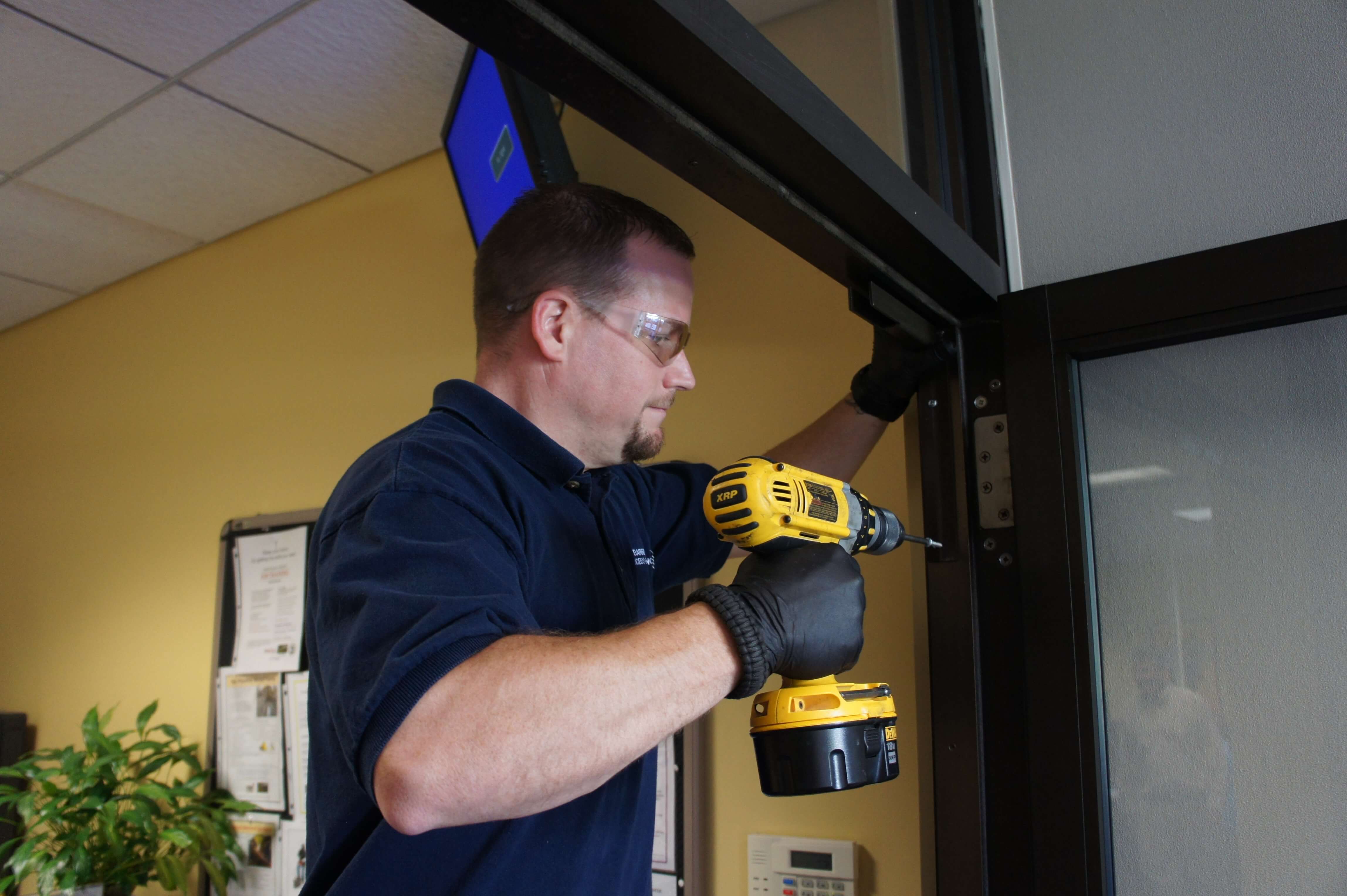 Man Installing a Slide Mounting Bracket before installing an automatic door opener while the door is open
