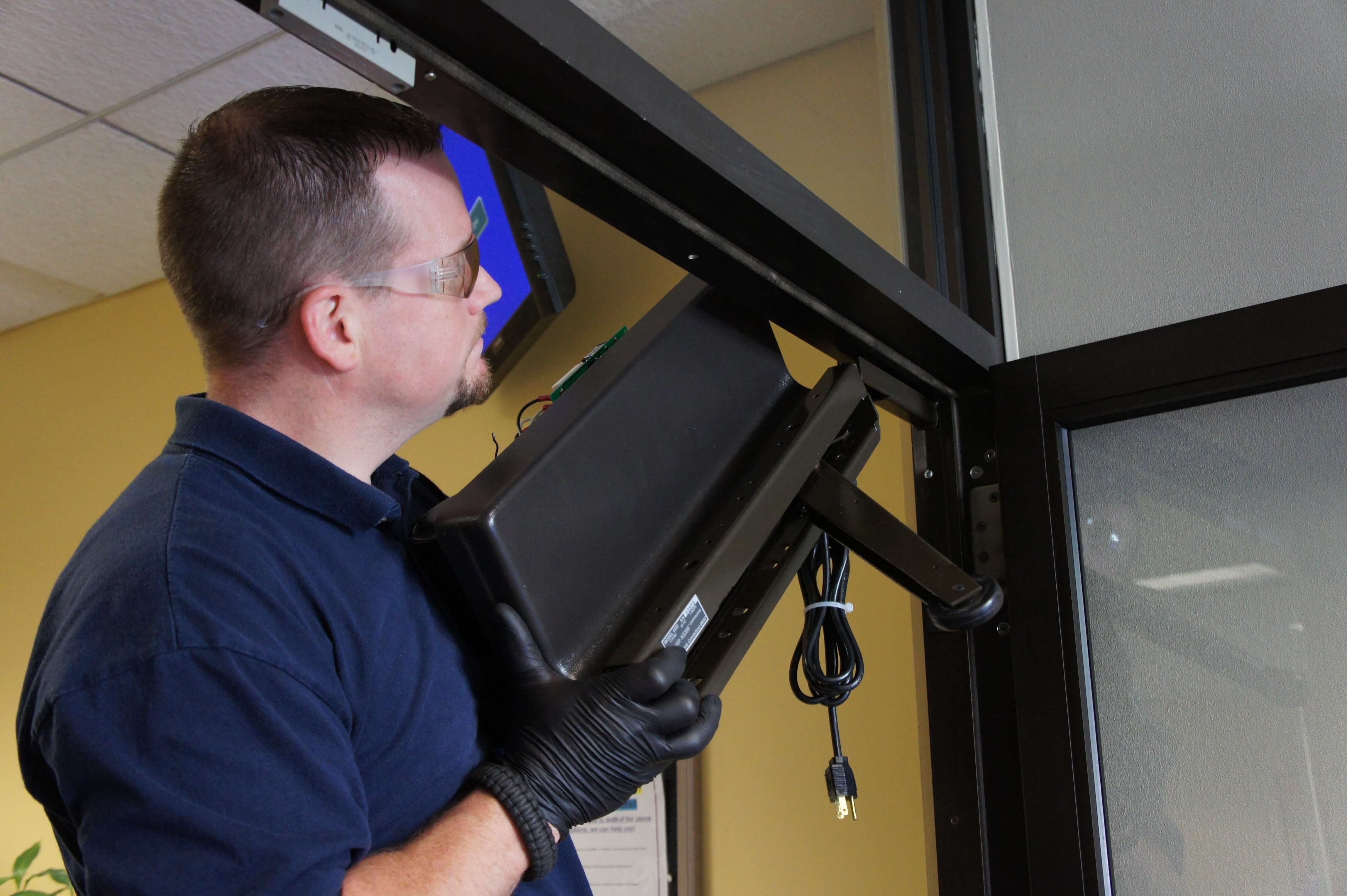 Man Putting Model 4300 Power Access Automatic Door Opener onto Slide Mount Bracket