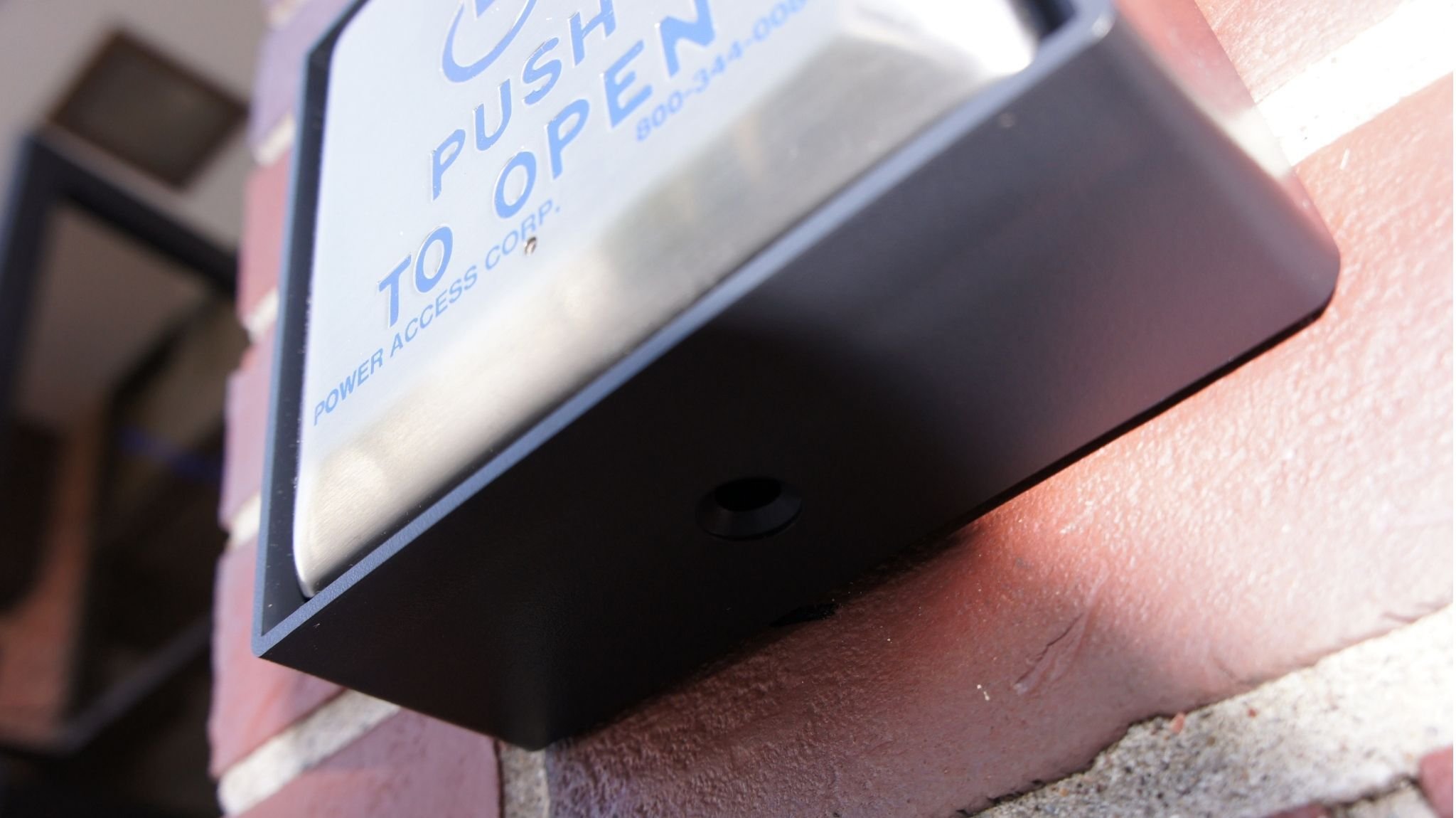 Installation of a Model 4495SQWR push plate that activates an automatic door opener on the exterior of a building