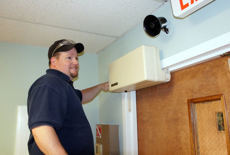 man finishing installation of a Model 4300L automatic door opener
