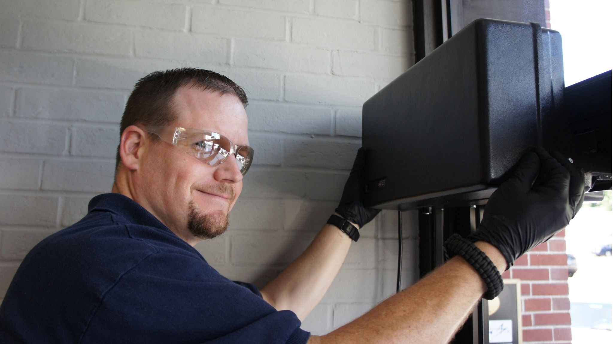 Man finishing an install of a Model 4310L on an exterior door